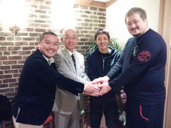 細見トレーナー、角谷選手、冴城トレーナーが市長と手と手を取り合って笑顔で写っている写真